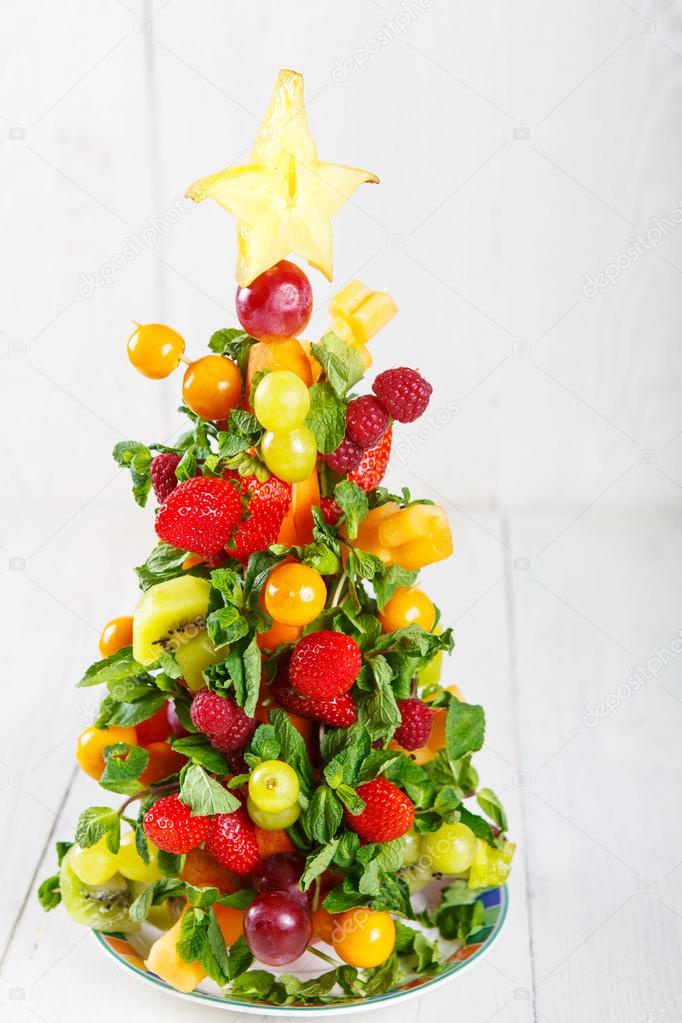 Creative fruit Christmas tree with different berries, fruits and