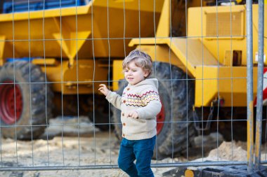 küçük çocuk izlerken Ekskavatör inşaat alanı, açık havada