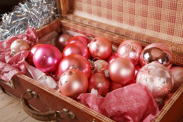 Antigos brinquedos de árvore de Natal rosa em mala antiga — Fotografia de Stock