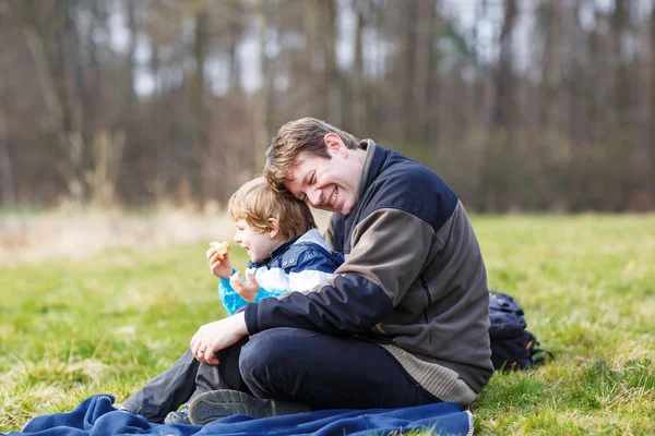Ung pappa och Lille son att ha picknick och kul nära skogen la — Stockfoto