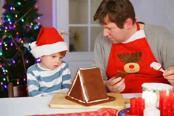 Pai e filho preparando uma casa de biscoitos de gengibre — Fotografia de Stock