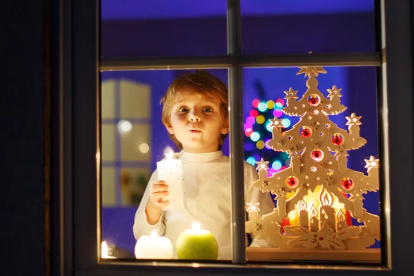 Little boy standing by window at Christmas time — Stock Photo, Image