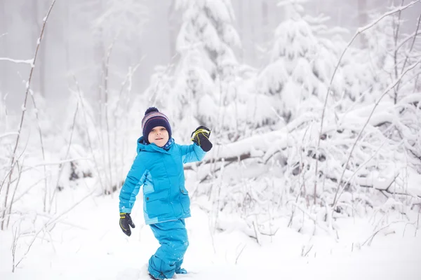 Pequeño niño divirtiéndose con nieve al aire libre en la hermosa wi — Foto de Stock