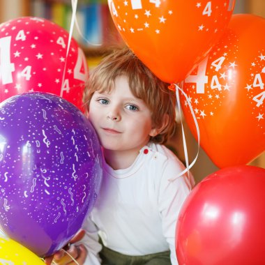 mutlu küçük çocuk kutluyor onun 4 renkli balloo doğum günü