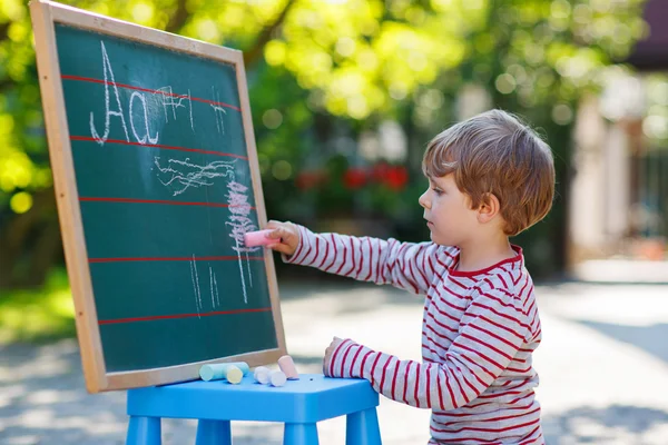 Menino no quadro negro praticando matemática — Fotografia de Stock