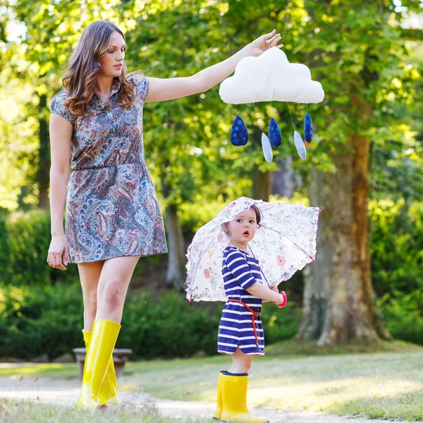 Mamma och lilla bedårande barn i gul gummi stövlar — Stockfoto