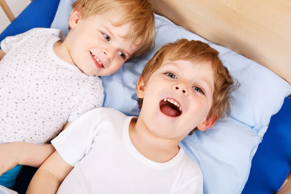 Két kis kisgyermek fiúk a szórakozás, az ágyban — Stock Fotó