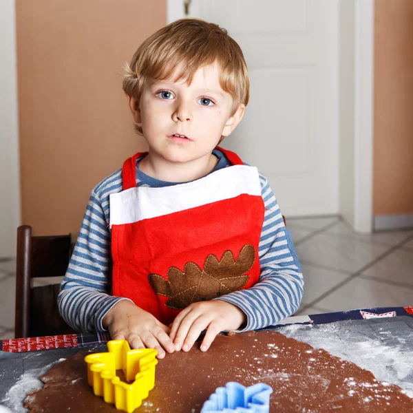 Bedårande pojke bakning ingefära bröd kakor till jul — Stockfoto