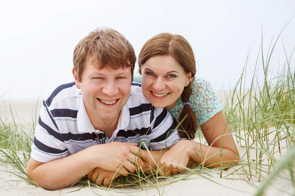 Young happy couple in love having fun on sand dunes of the beach — Stock Photo, Image