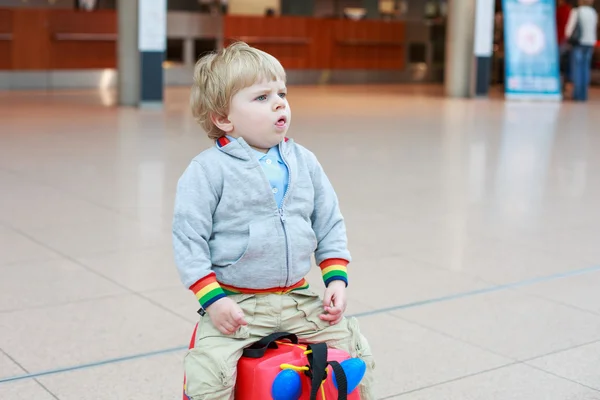 Funny toddler boy going on vacations trip with suitcase at airpo — Stock Photo, Image