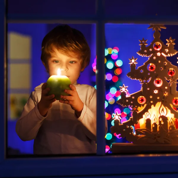 Little boy standing by window at Christmas time — Stock Photo, Image