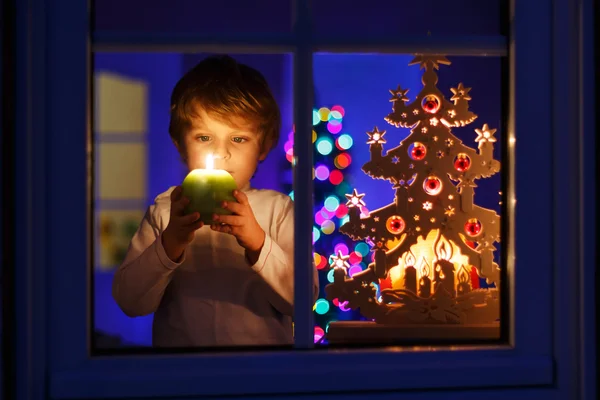 Kleine jongen permanent door venster bij Kerstmis — Stockfoto