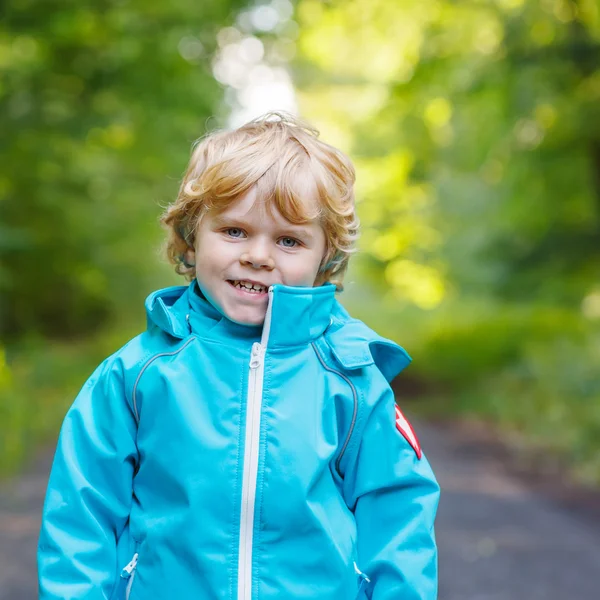 Portret van blond kleine peuter jongen in blauwe waterdichte raincoa — Stockfoto