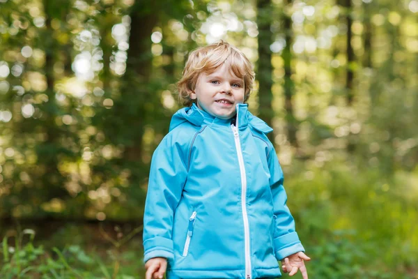 Porträt eines kleinen blonden Jungen in blauem, wasserdichtem Regenkakao — Stockfoto