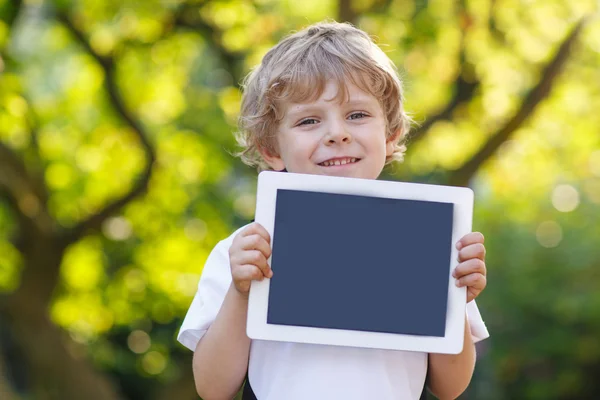 Leende glada lilla barnet hålla TabletPC, utomhus — Stockfoto