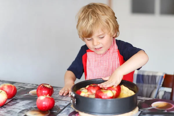 Adorabile ragazzino che aiuta e cuoce la torta di mele in kitc casa — Foto Stock