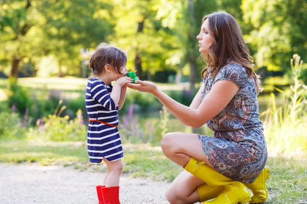 Mother and little adorable toddler daughter in yellow rubber boo — Stock Photo, Image