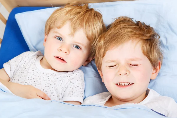 Kleine broer of zus jongens plezier in bed thuis — Stockfoto