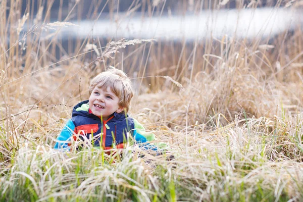 Piccolo bambino che si diverte vicino al lago della foresta, natura — Foto Stock