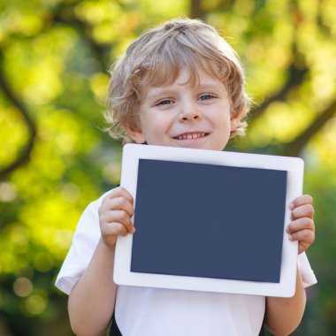 tablet pc, açık havada tutan gülümseyerek mutlu küçük çocuk