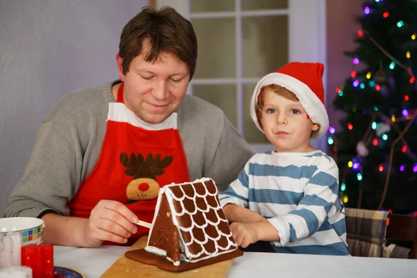Father and little son preparing a gingerbread cookie house — Stock Photo, Image
