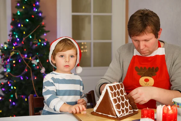 Father and little son preparing a gingerbread cookie house — Stock Photo, Image