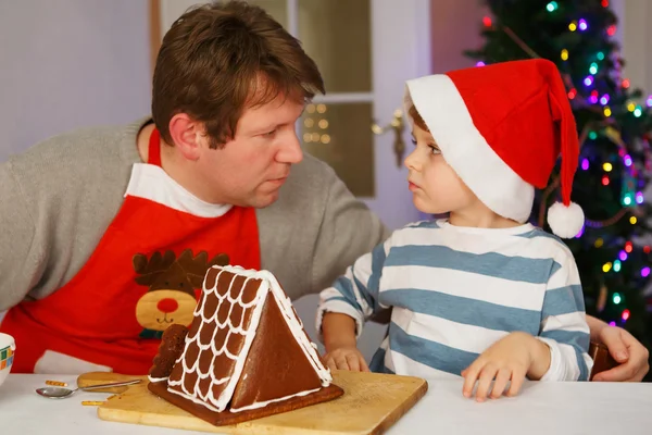 Père et petit fils préparant une maison de biscuits au pain d'épice — Photo