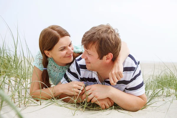 Young happy couple in love having fun on sand dunes of the beach — Stock Photo, Image