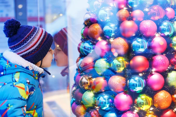 Roztomilý chlapeček, dívali se oknem na vánoční výzdoba — Stock fotografie