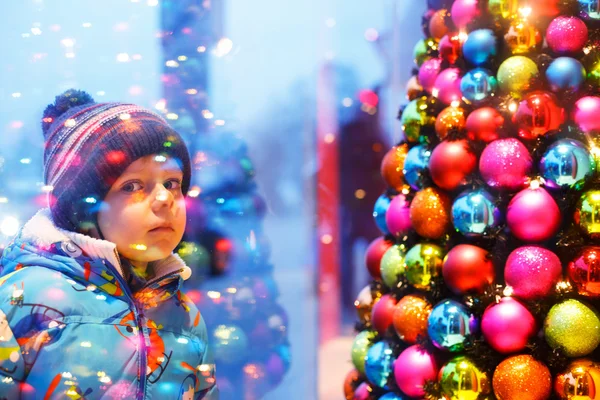 Roztomilý chlapeček, dívali se oknem na vánoční výzdoba — Stock fotografie