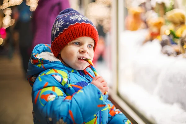 Schattige kleine jongen op zoek door het raam op Kerstmis deco — Stockfoto