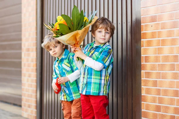 Deux heureux adorables petits frères et sœurs avec des fleurs en fleurs — Photo
