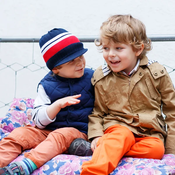 Dwóch chłopców szczęśliwy na hollywood huśtawka w ogrodzie wiosna — Zdjęcie stockowe