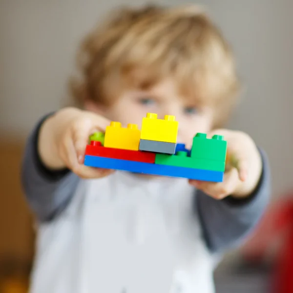 Menino pequeno feliz brincando com blocos de construção com creat — Fotografia de Stock