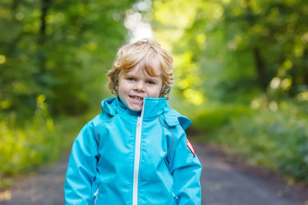 Retrato de loiro menino criança em azul impermeável raincoa — Fotografia de Stock