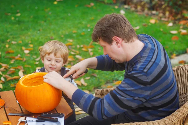 Jovem e criança menino fazendo abóbora halloween — Fotografia de Stock