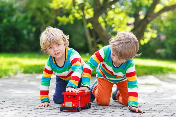 Kırmızı okul otobüsü ile oynayan iki küçük çocuklar — Stok fotoğraf