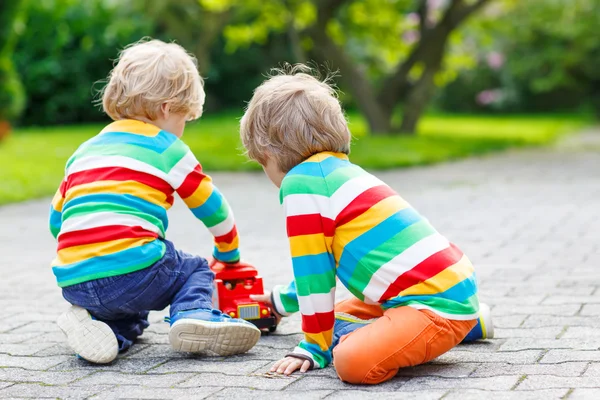 Två syskon, kid pojkar leker med röda skolbuss — Stockfoto