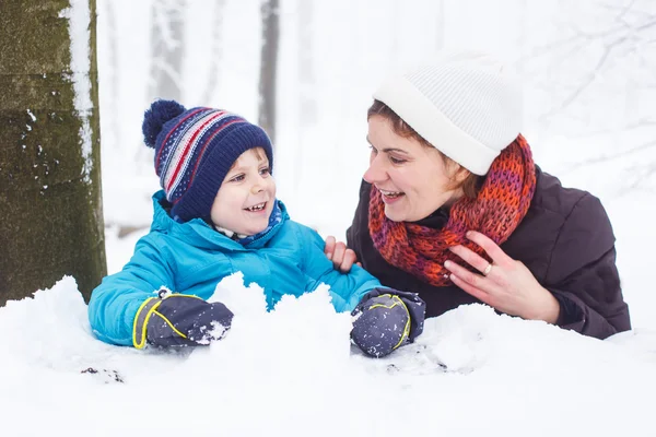 Happy family: mother and little son having fun with snow in wint — Stock Photo, Image