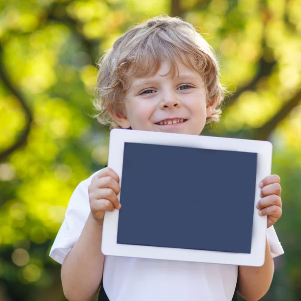 Sorrindo feliz criança segurando tablet pc, ao ar livre — Fotografia de Stock