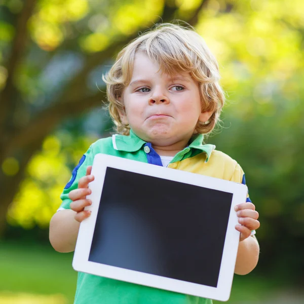 Bedårande glad liten unge pojke håller TabletPC, utomhus — Stockfoto