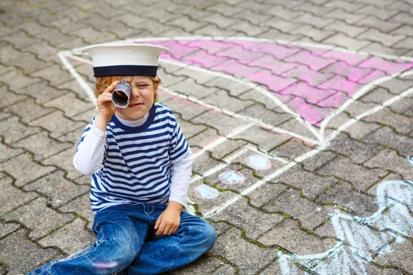 Kleine jongen met plezier met schip afbeelding tekenen met krijt — Stockfoto