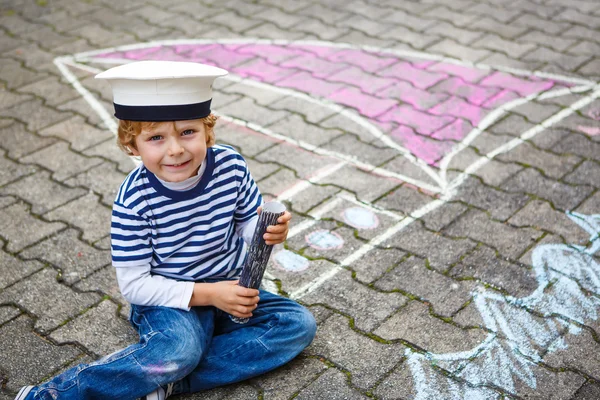 Menino se divertindo com desenho de imagem de navio com giz — Fotografia de Stock