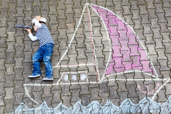 Niño divirtiéndose con el dibujo de la imagen de la nave con tiza —  Fotos de Stock