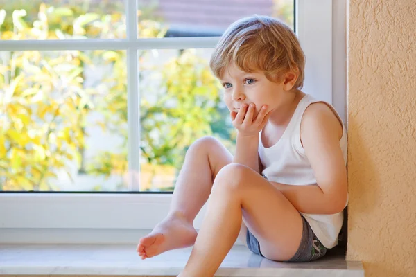 Mały chłopiec trzech lat patrząc przez okno na żółty au — Zdjęcie stockowe
