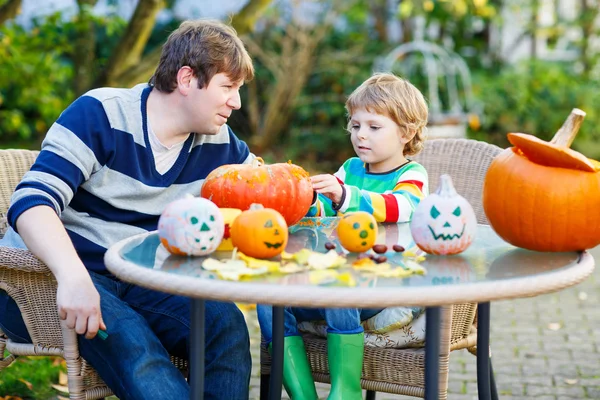 Menino adorável e seu pai fazendo jack-o-lanterna para hallo — Fotografia de Stock