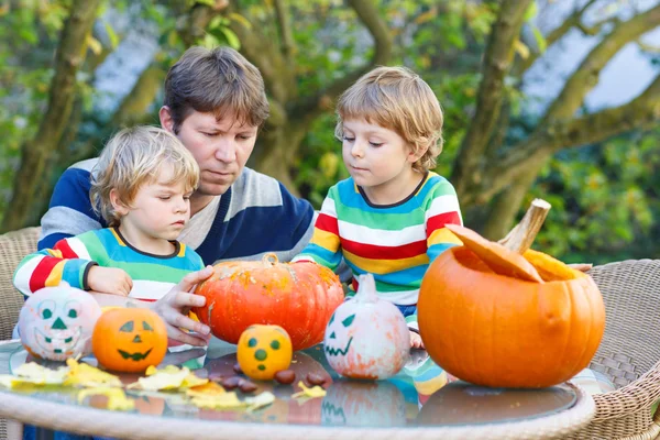 Jonge vader en twee kleine zonen maken hefboom-o-lantaarn voor hallo — Stockfoto