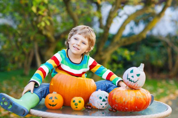 Niño pequeño haciendo jack-o-linterna para Halloween en otoño gar —  Fotos de Stock