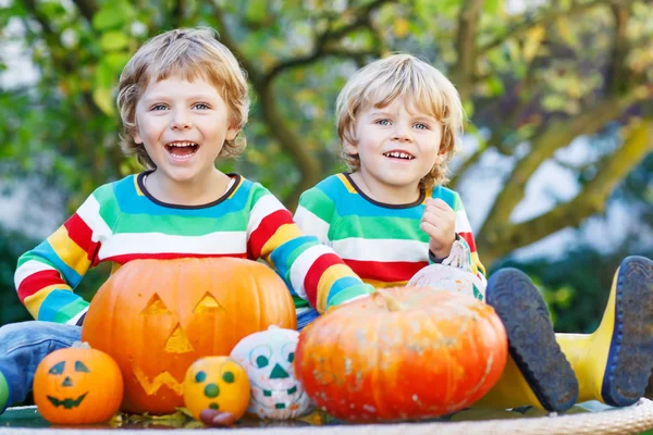 Two little kid boys making jack-o-lantern for halloween in autum — Stock Photo, Image