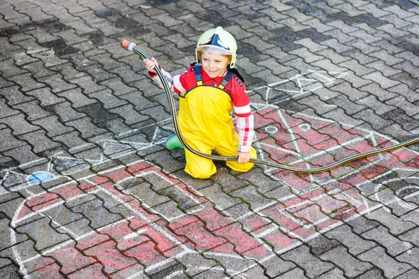 Lustiger kleiner Junge hat Spaß mit Feuerwehrauto-Bild-Zeichnung mit — Stockfoto